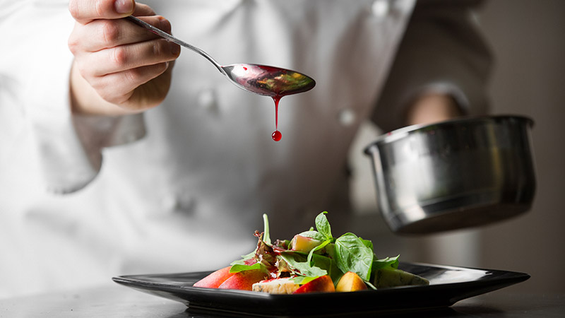 A chef finishing a dish.