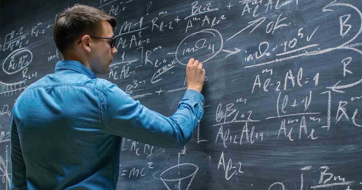 Man writing on chalkboard.